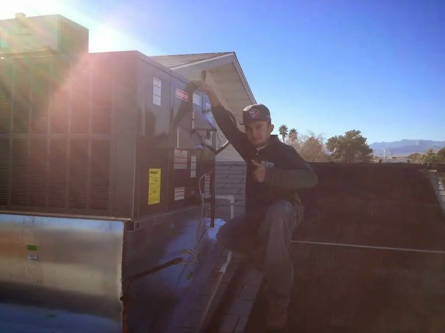 HVAC technician performing Air Duct Repair on a rooftop unit in Newtown